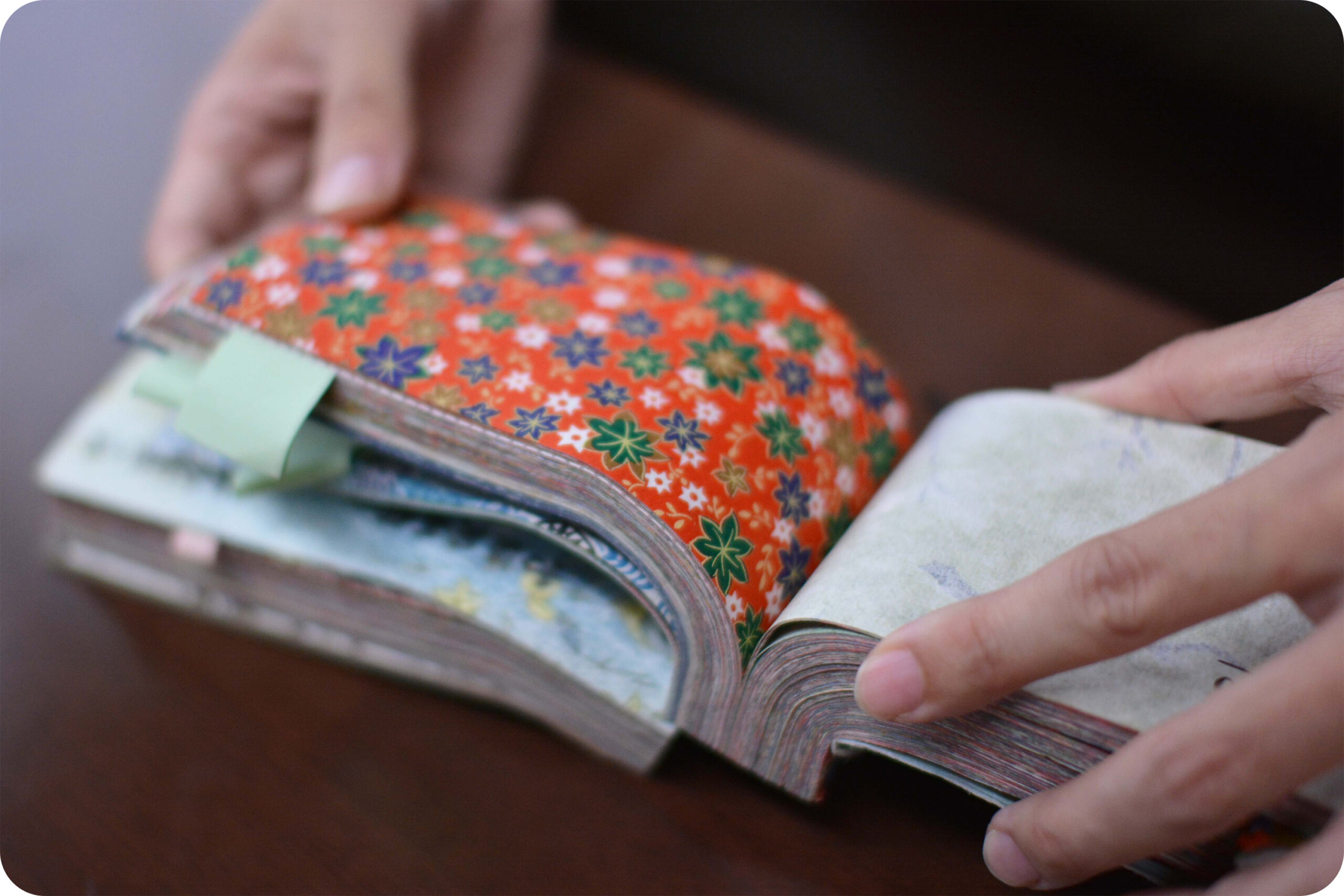 和紙カタログ。千代紙のような色鮮やかな花柄模様のページが開く。