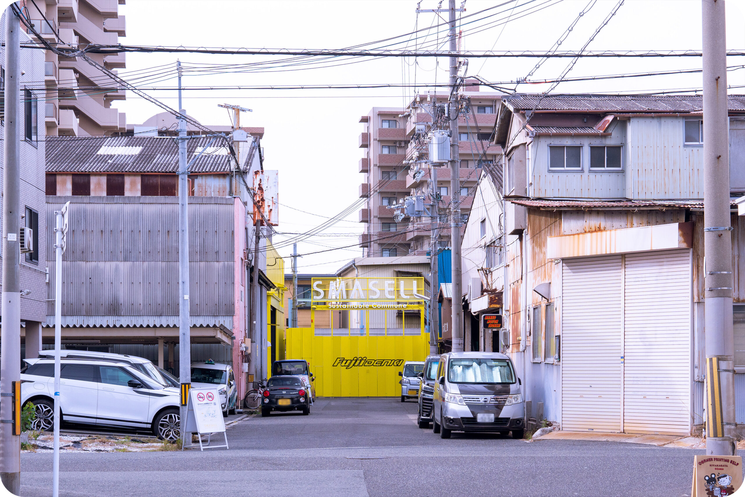 工場跡地、倉庫、住居が立ち並ぶ北加賀屋の町。SMASELLの黄色い看板が見える。